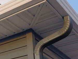 close-up of steel soffit and fascia with gutter downspout